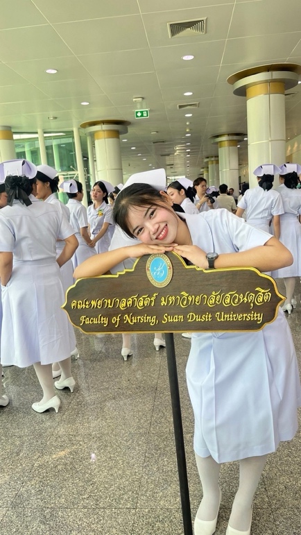 A child in white gowns holding a sign Description automatically generated