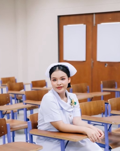 A person in a white uniform sitting at a desk Description automatically generated
